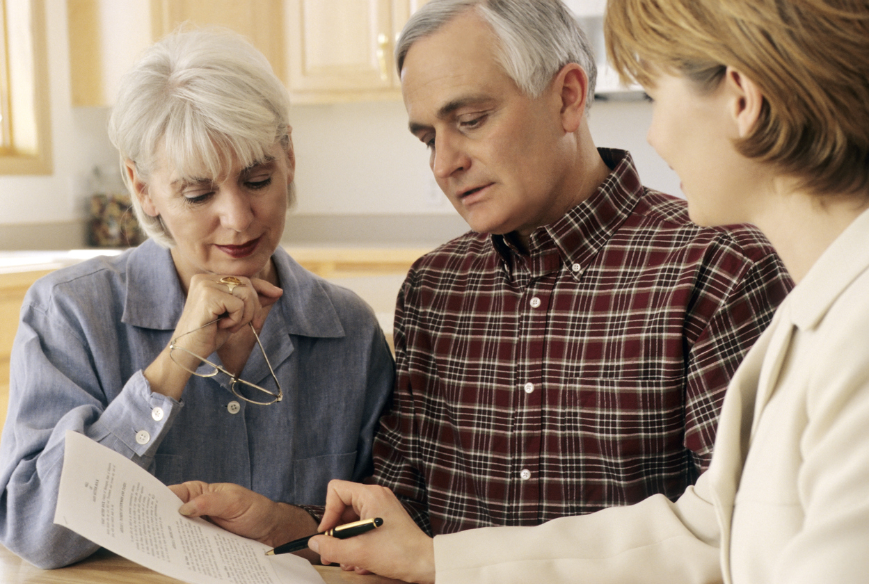 Elderly couple meeting with an agent to sign a will