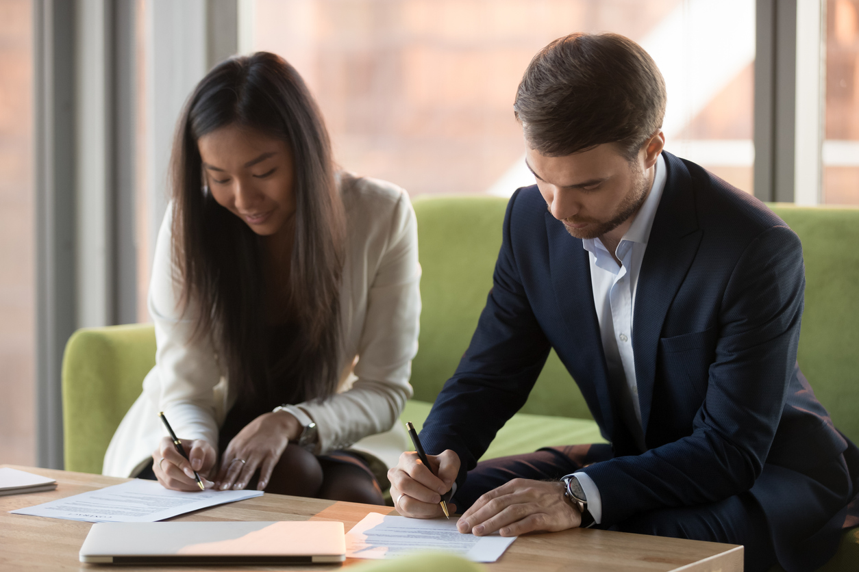 Young businesspeople signing prenuptial agreement