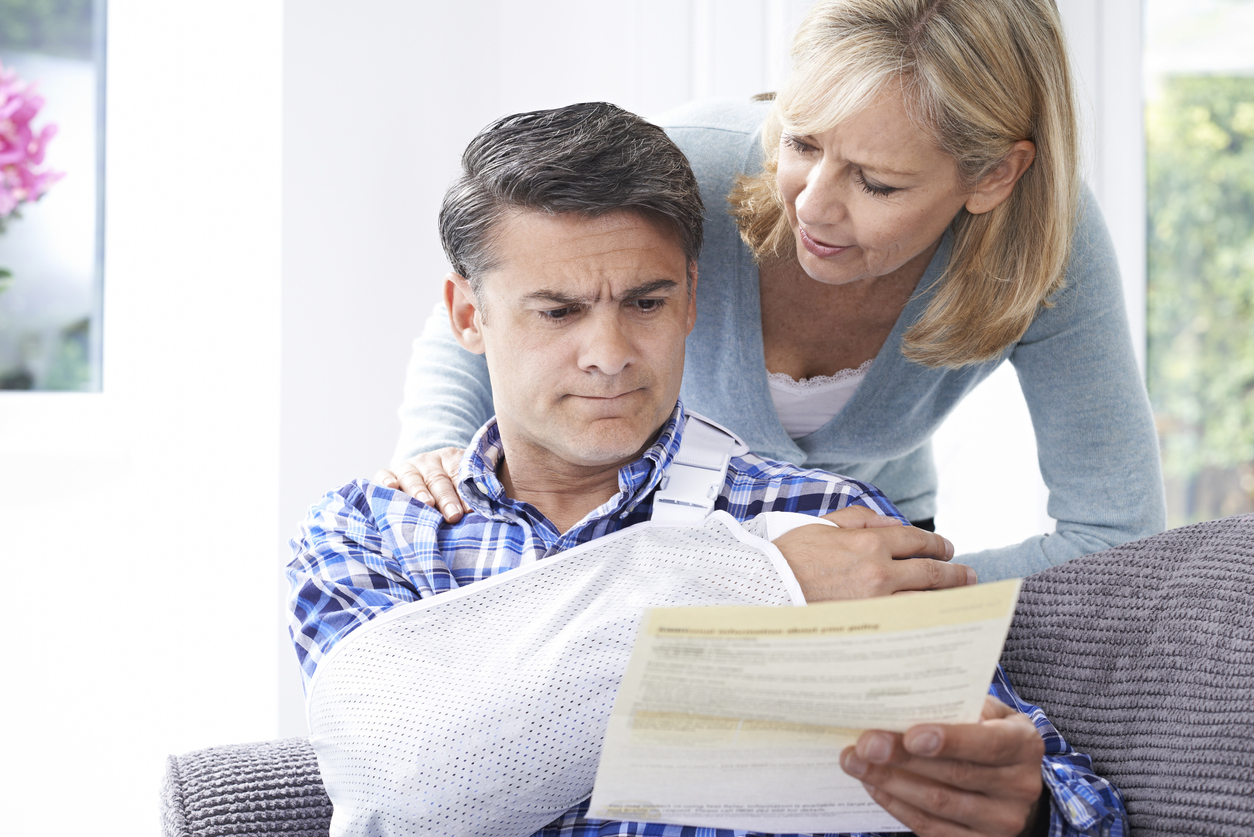 Couple reading insurance letter about husband's injury