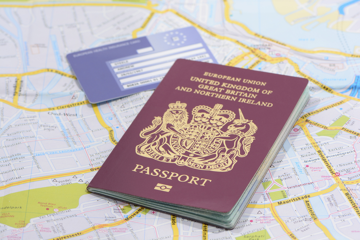 United Kingdom passport and EU health card on a road map