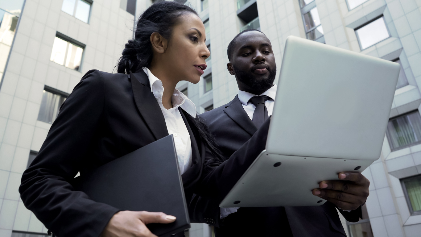 Attorneys looking at laptop outside building