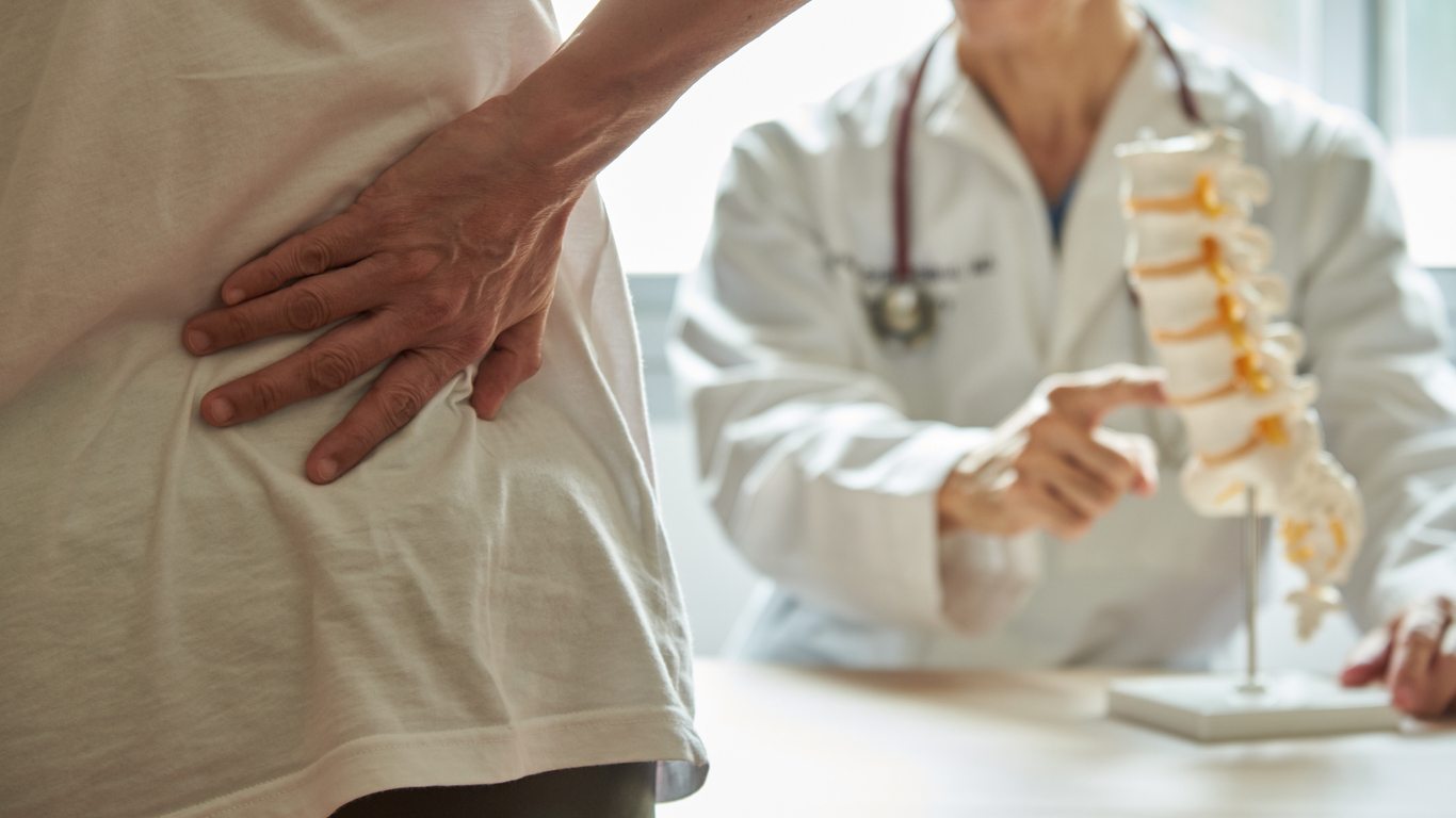 Doctor explaining lumbar anatomy to patient with back pain