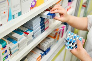 Pharmacist taking medicine off a shelf