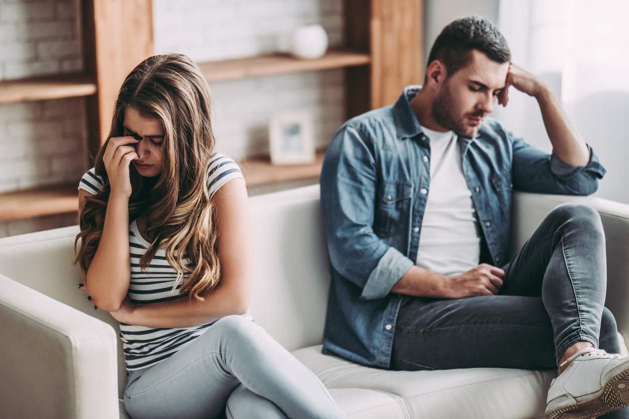 Upset couple sitting on couch