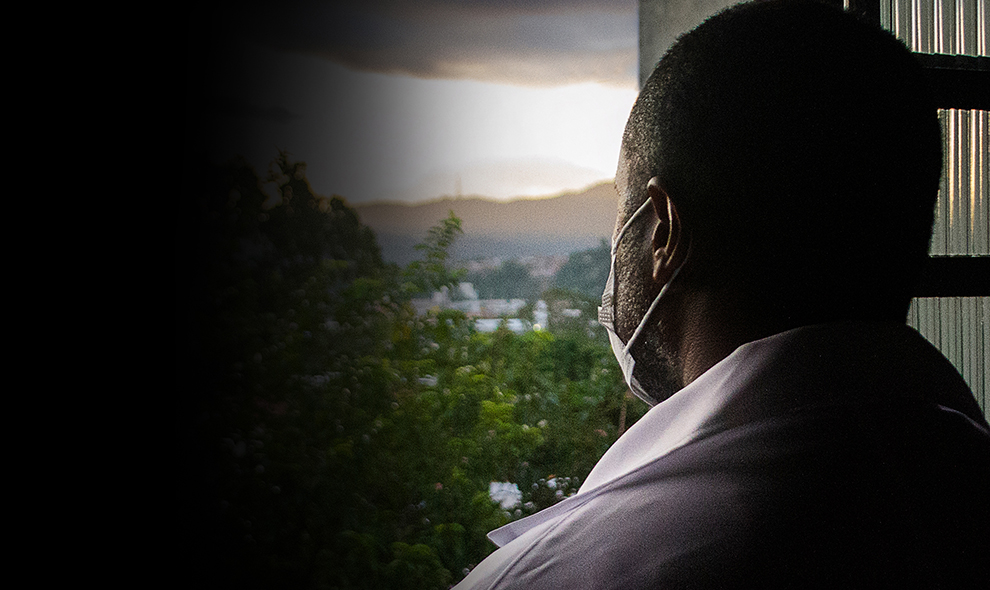 Man in mask looking out of window