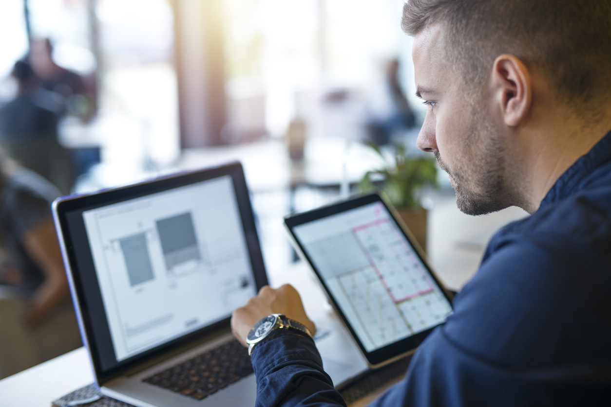 Young male attorney using laptop and tablet