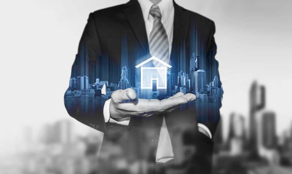 Businessman holding modern buildings hologram, and home icon. Real estate business, building technology and smart home concept