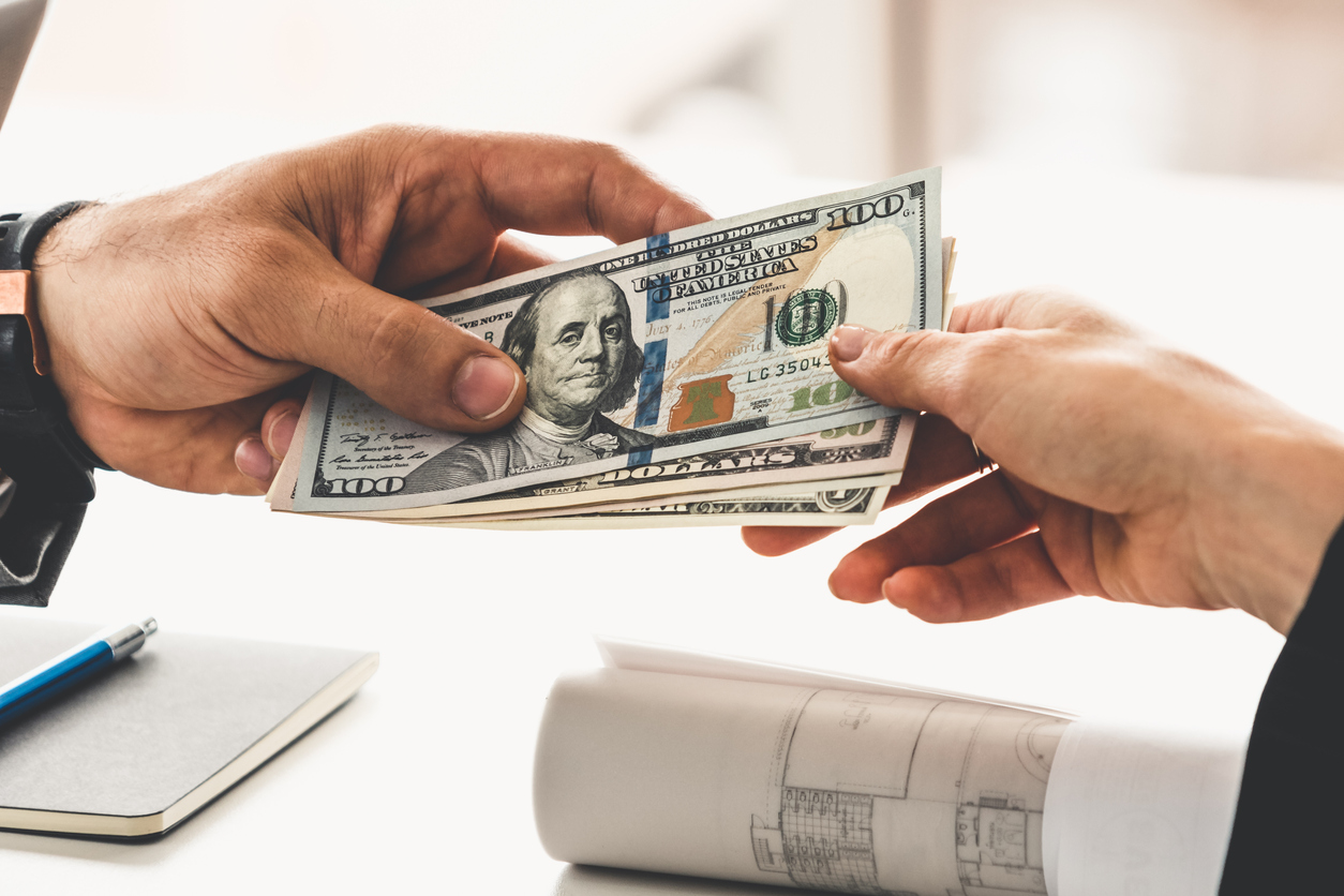 Businessmen exchanging hundred-dollar bills