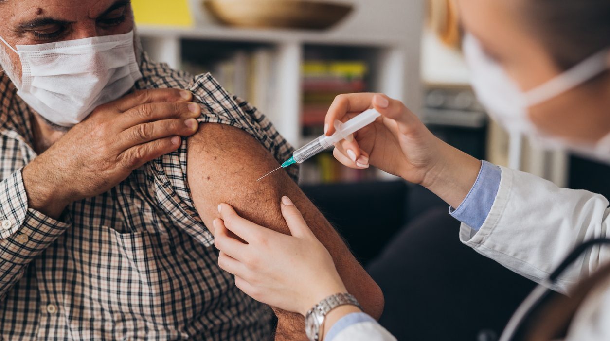 Masked patient receiving a COVID-19 vaccination