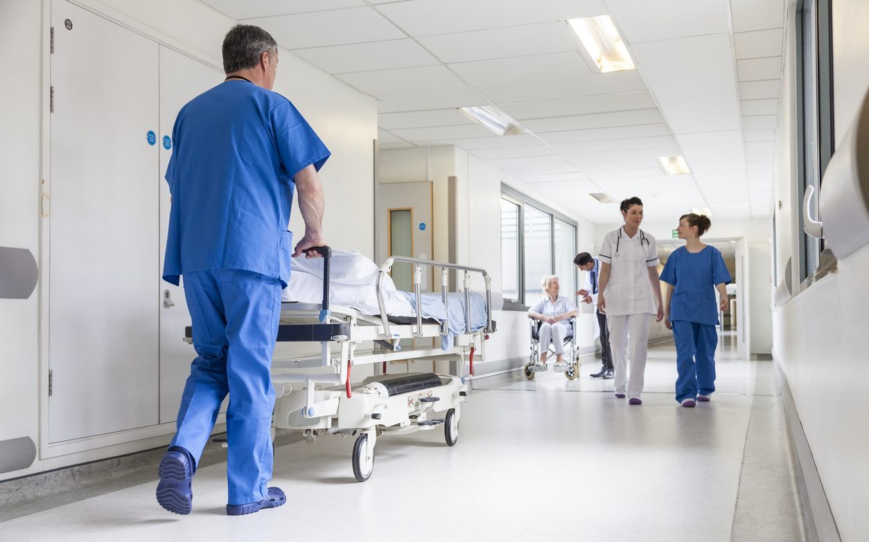 Nurse pushing a gurney in a hospital corridor