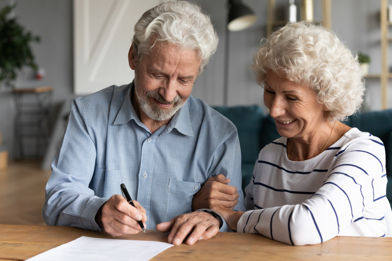 Older couple signing a legal document