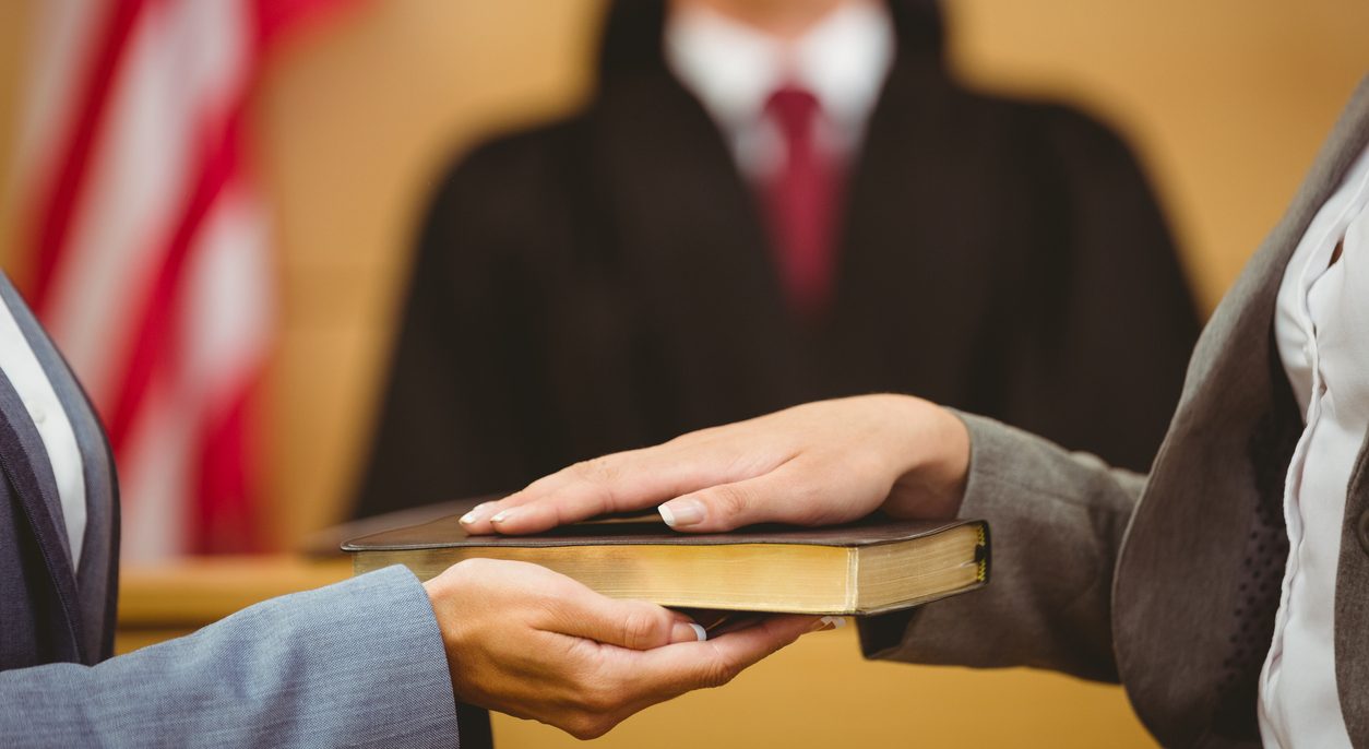 Witness swearing on the Bible in a courtroom