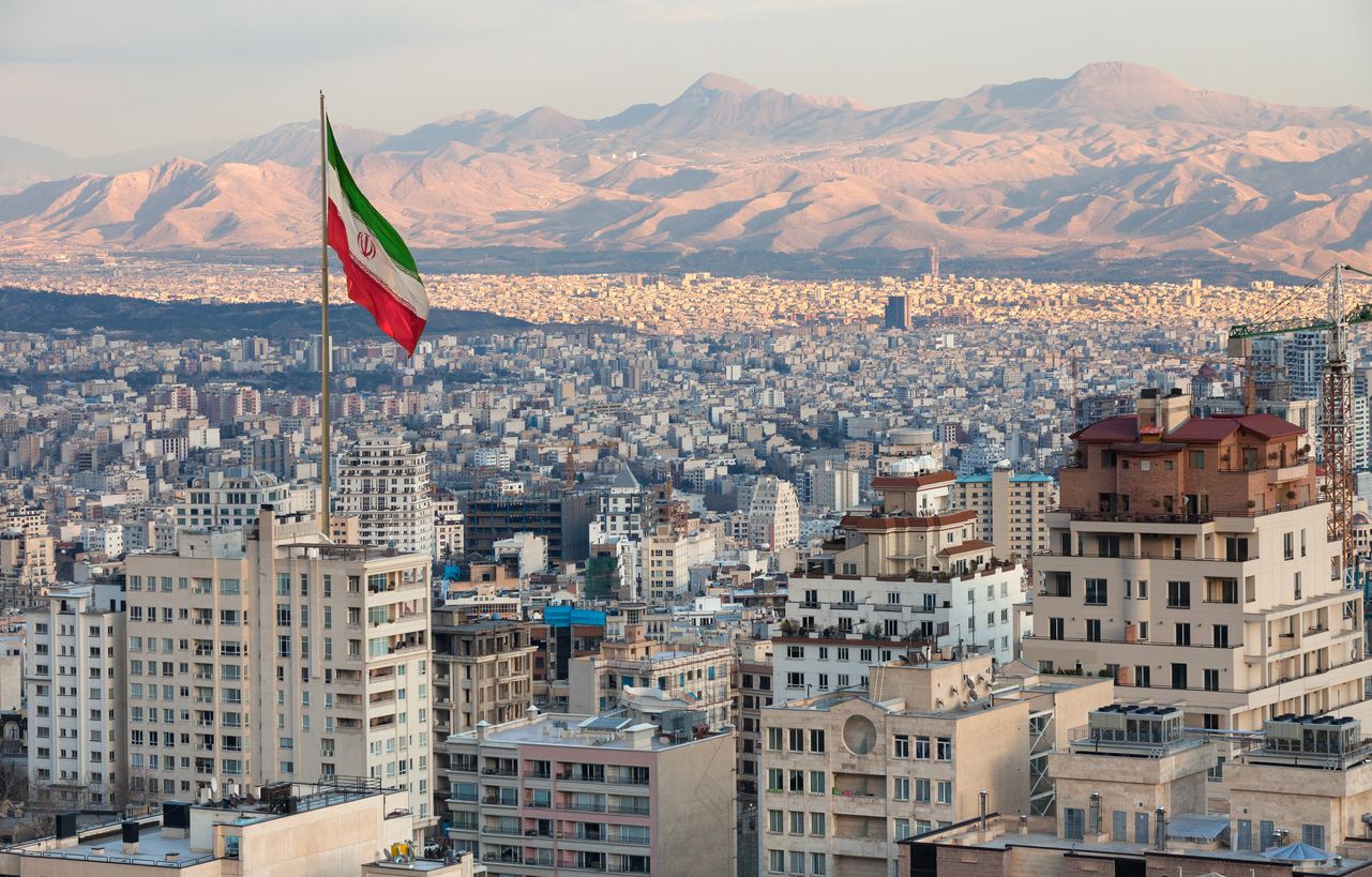 Iranian flag above the Tehran skyline