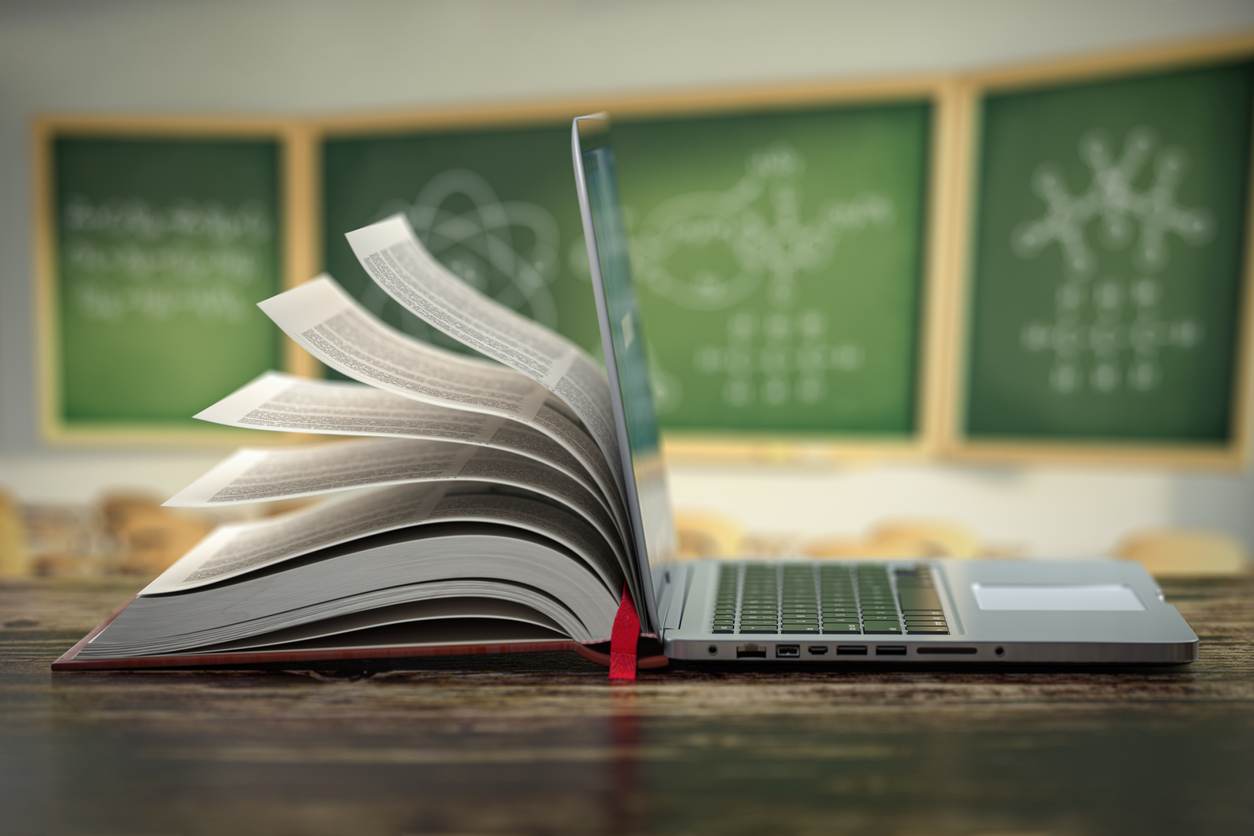 Open book and laptop in a classroom