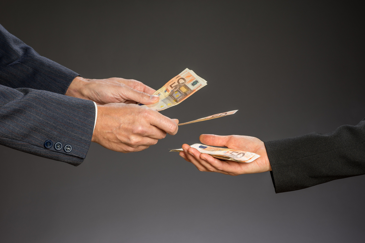 Deal! Businessman paying money (fifty euros) to businesswoman. Woman and man hand on a gray background.