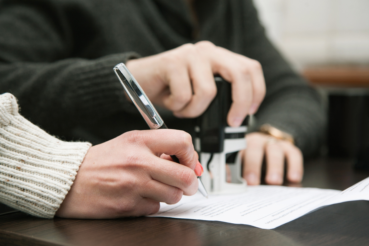 Hand signing paper with help of mentor