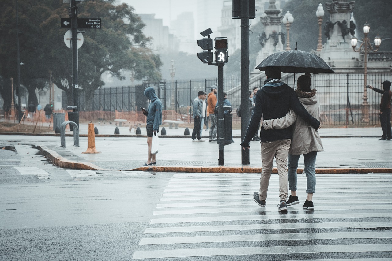 Pedestrians crossing road in rain