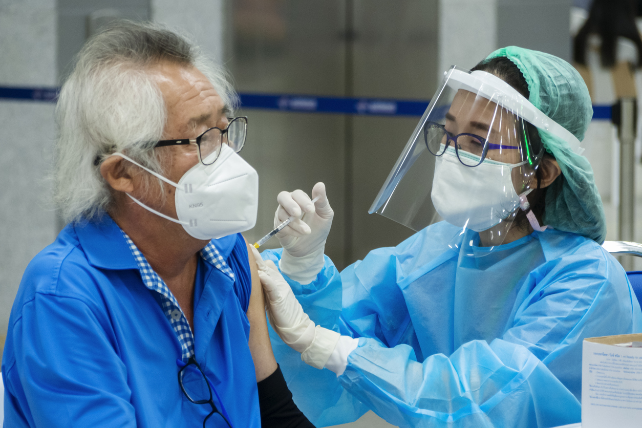 Medical professional administering Covid-19 vaccine to patient