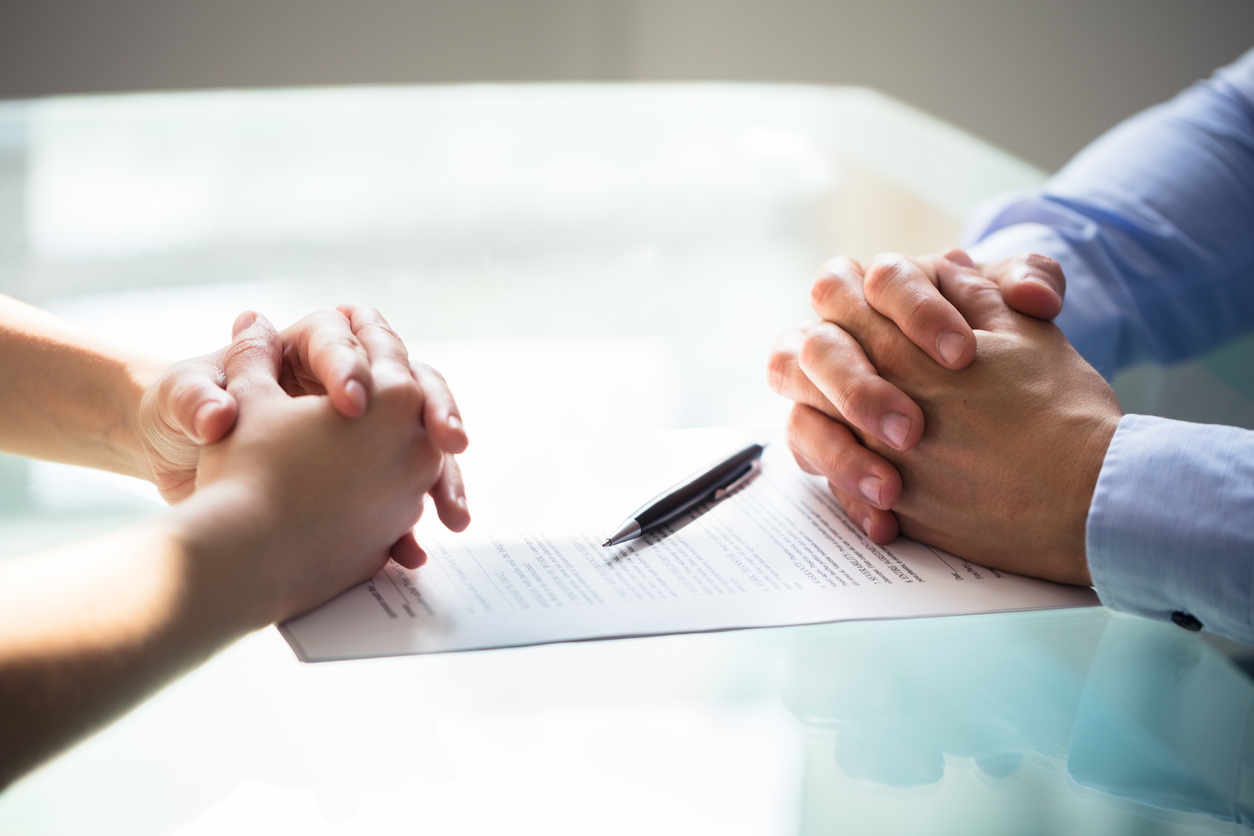 Folded hands of couple on divorce papers