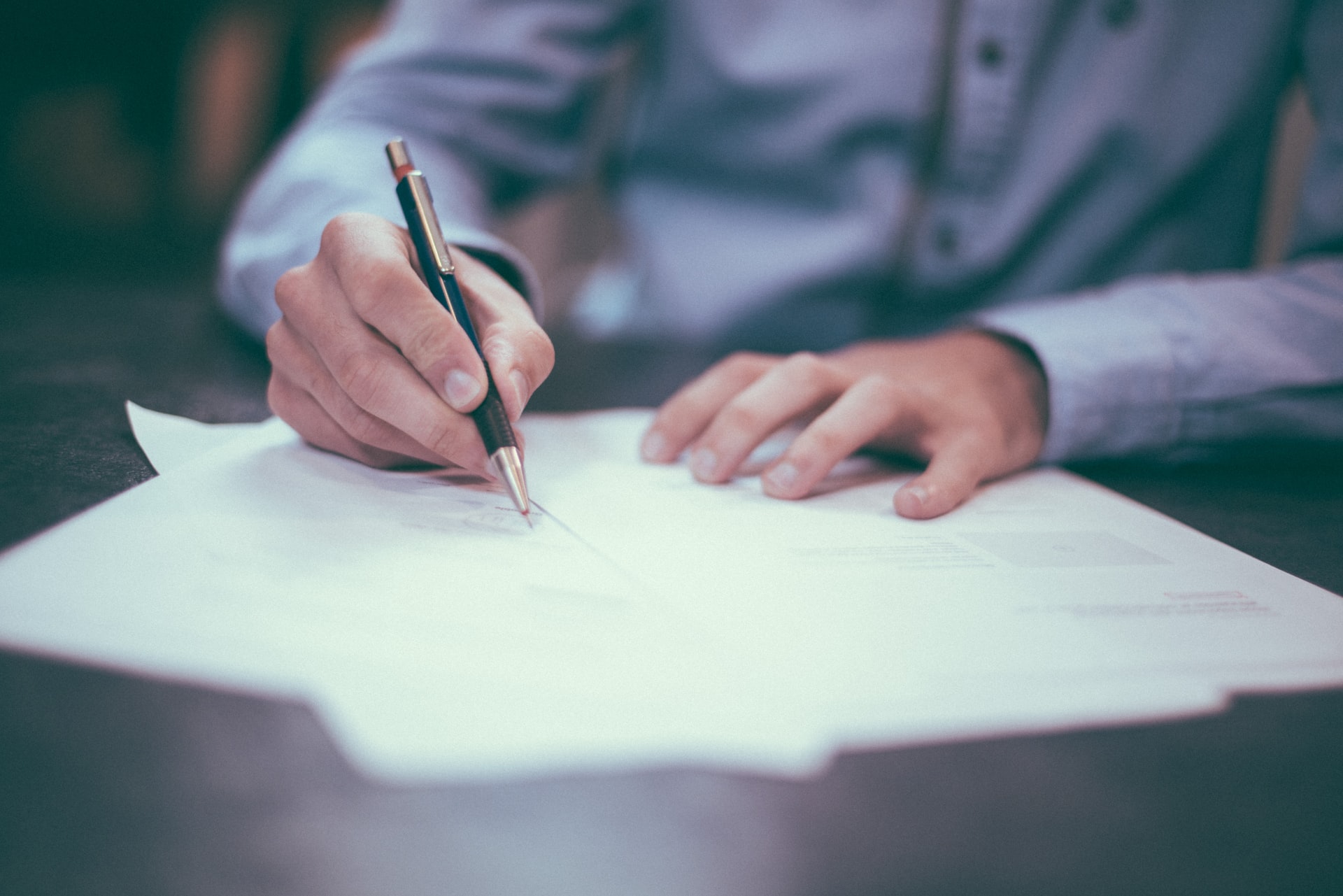 Man signing sheet of paper