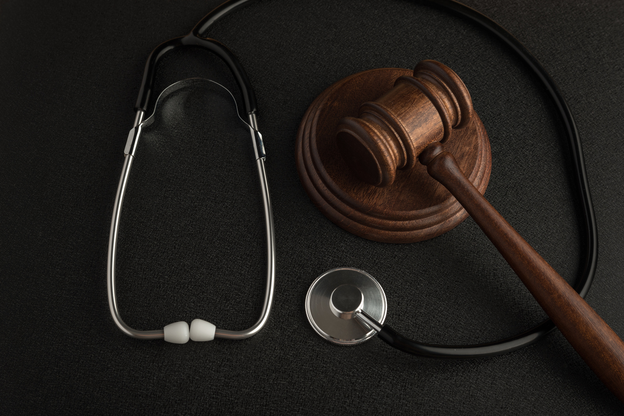 Personal injury; Gavel hammer and stethoscope on black background