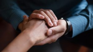 Hands holding one another, showing empathy