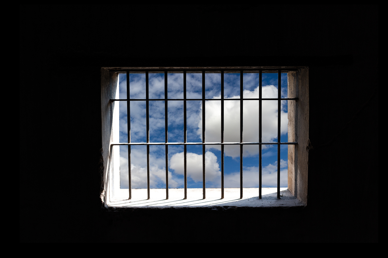 Blue sky outside jail bars