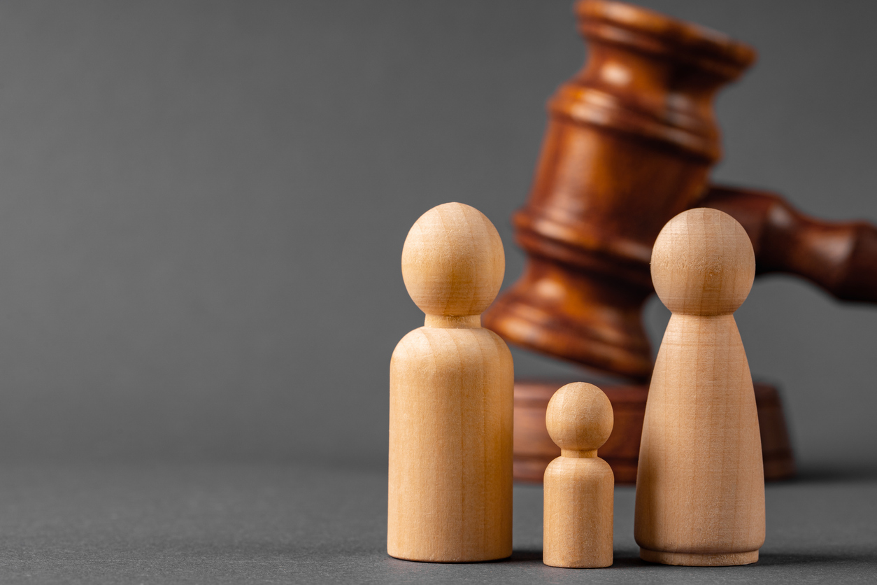 Wooden toy family and judge mallet. Family divorce concept