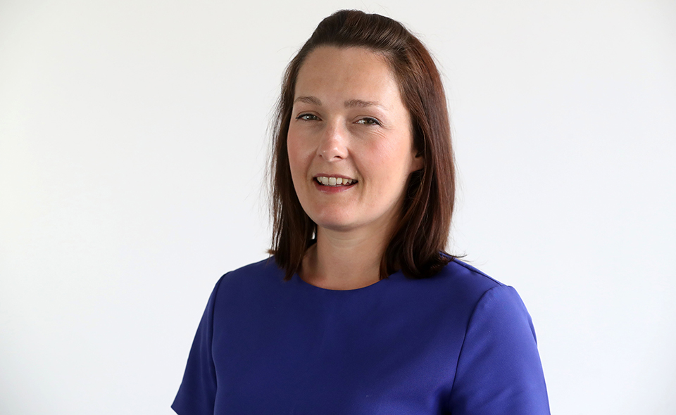 Employment law specialist standing in front of white background.