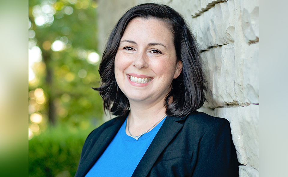 Smiling female estate planning lawyer in front of building.