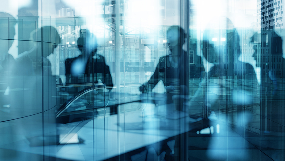 Stock graphic of individuals gathered around a boardroom table