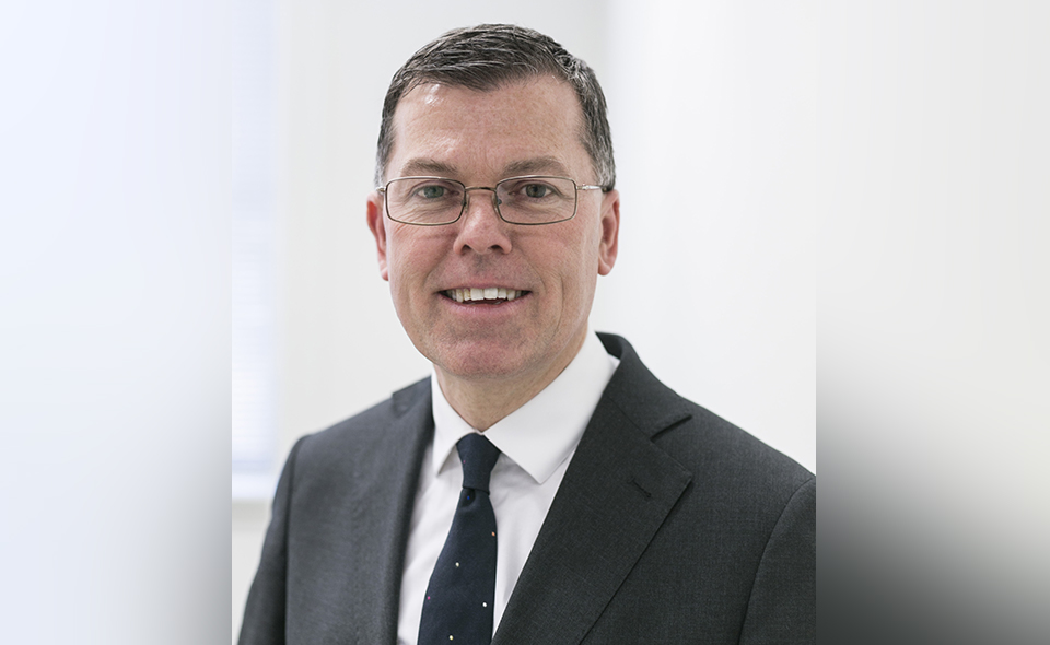 Insurance expert wearing a grey suit in his office.