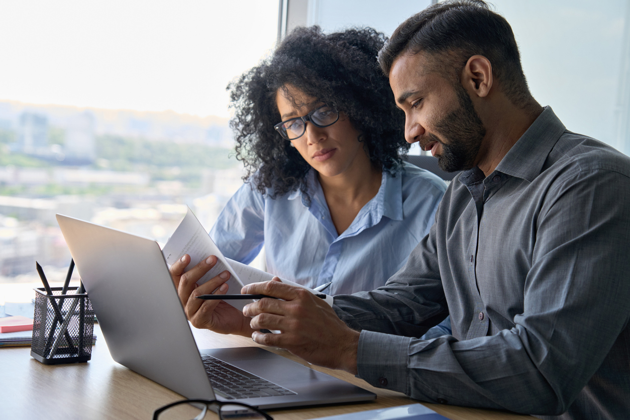 Lawyer and intern working at a laptop.