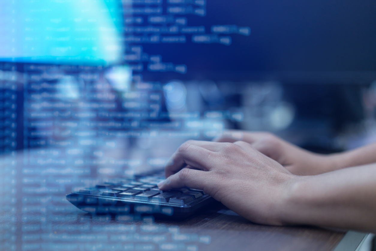 close up programmer man hand typing on keyboard at computer desktop for input coding language to software for fix bug and defect of system in operation room , technology concept