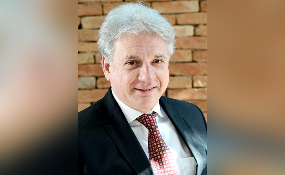 Insurance and reinsurance specialist Luis Felipe Pellon standing in front of a brick wall.