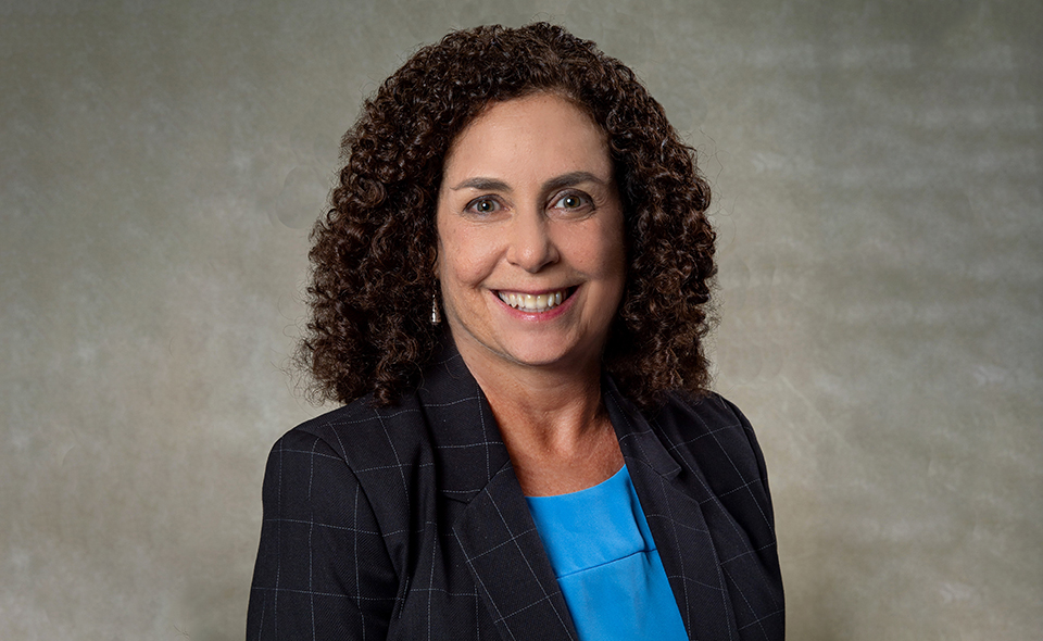 Personal injury lawyer Julie Siegel standing in front of a beige wall.