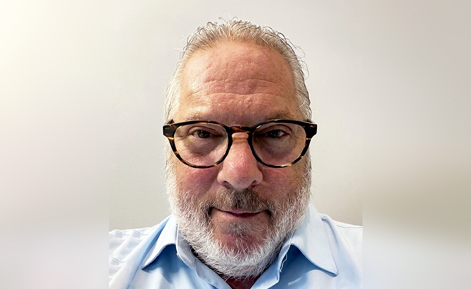 Process service specialist Harlin Parker standing in front of a white wall.