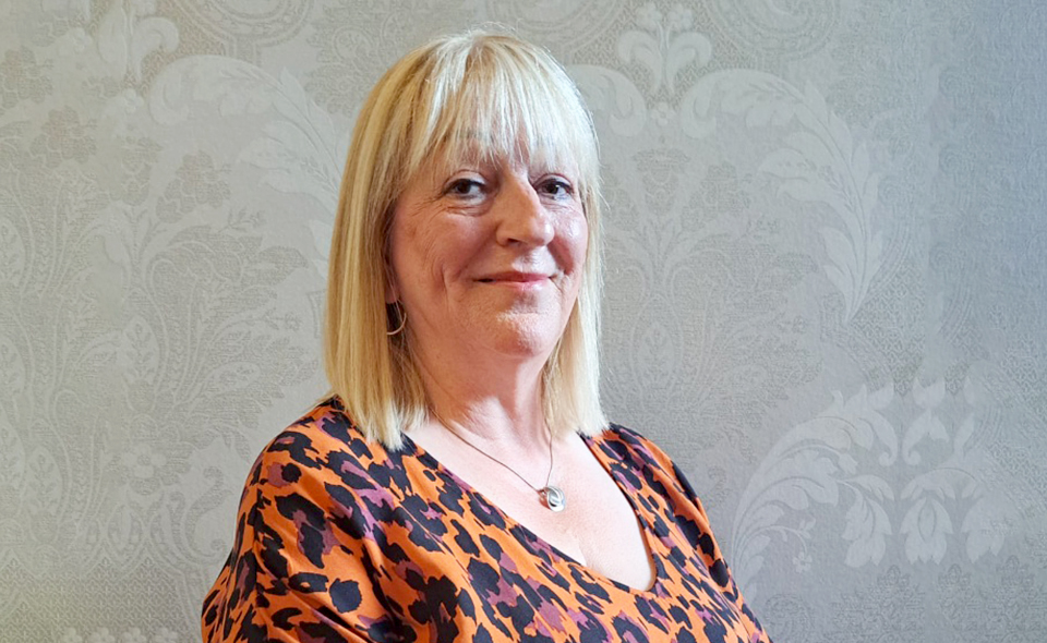 Family mediation specialist Joan Davis standing in front of a wall.