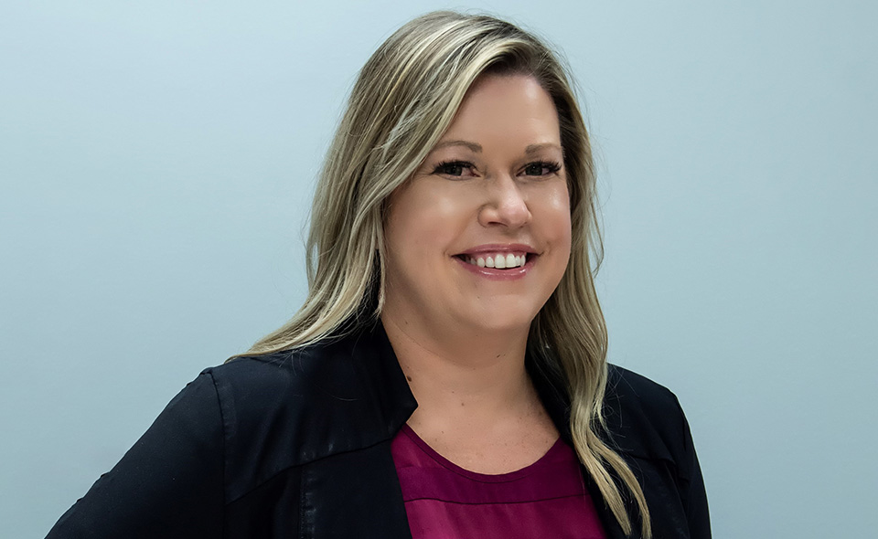 Legal nurse consultant Lisa Ortega standing in front of a plain wall.