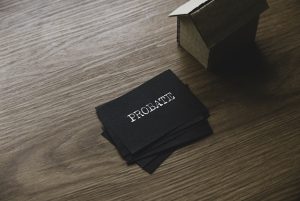 Selective focus of a stack of black paper written with Probate and small cardboard house.