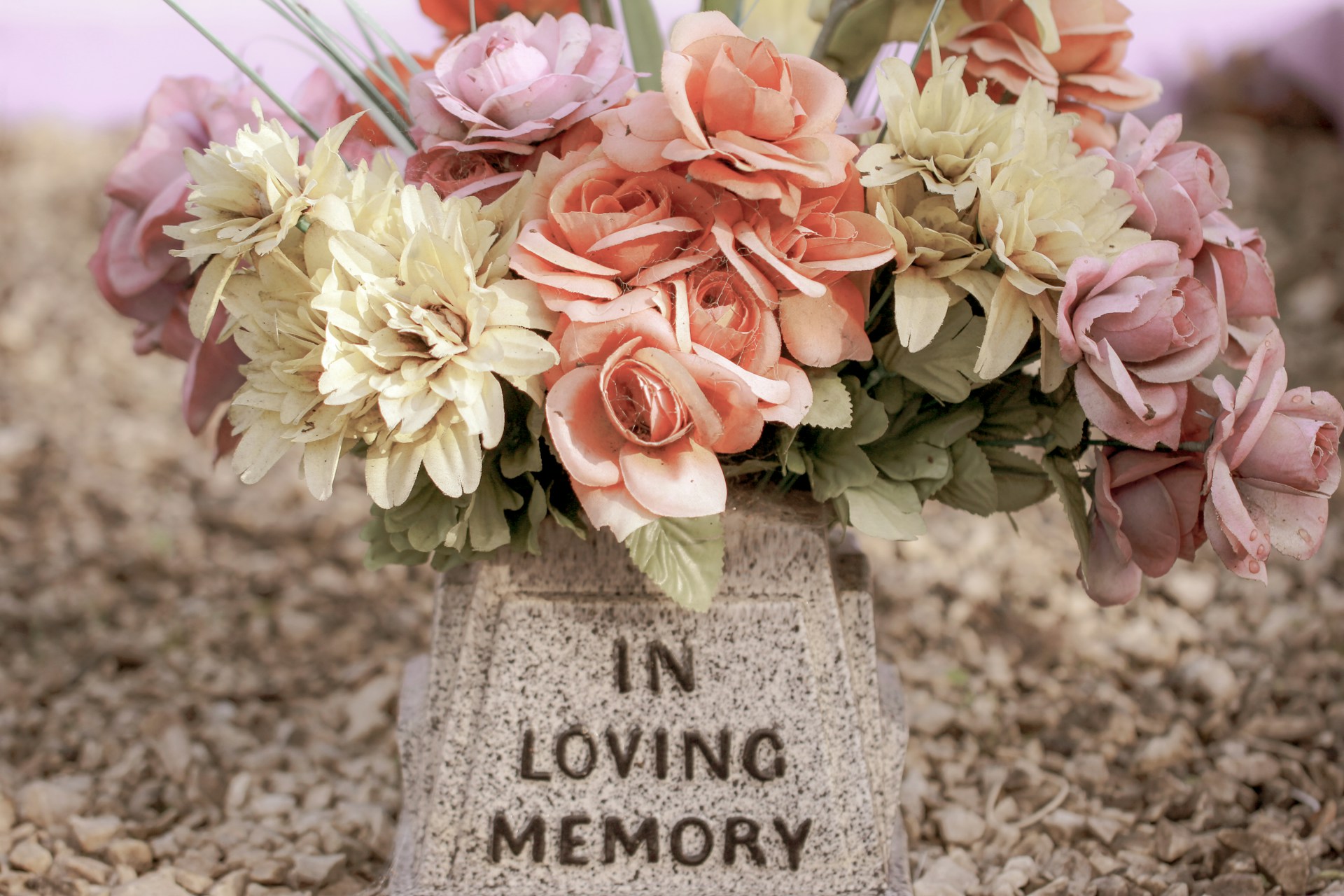 Funeral Wreath Laid above a tombstone which says "In Loving Memory".