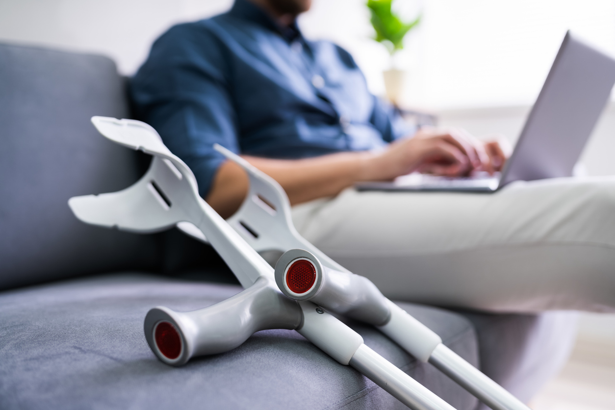 man with leg injury using laptop