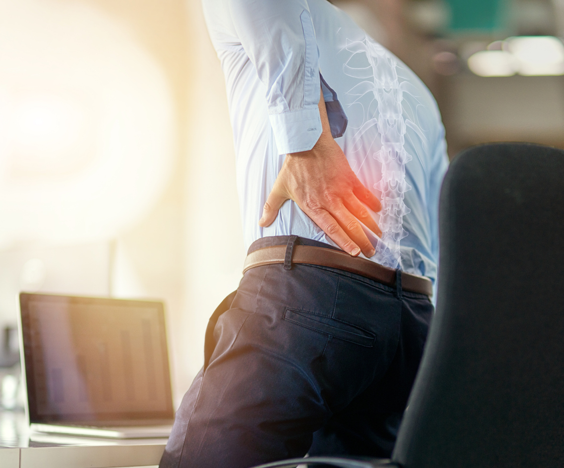 businessman, back pain and x ray of spine from sitting and working by laptop on desk chair at the office. employee male suffering spinal injury or slip disk with ache, inflammation or painful join