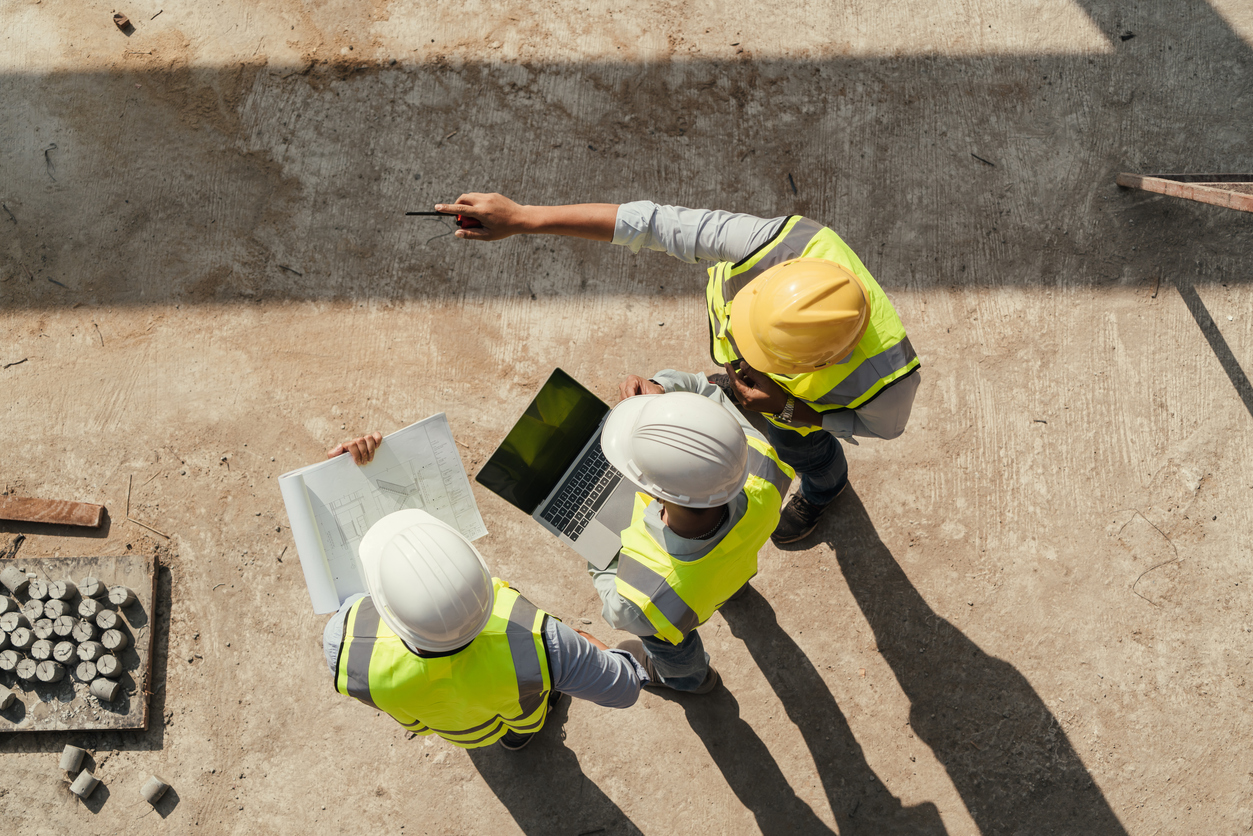 top view, team engineer building inspection use tablet computer and blueprint working at construction site.