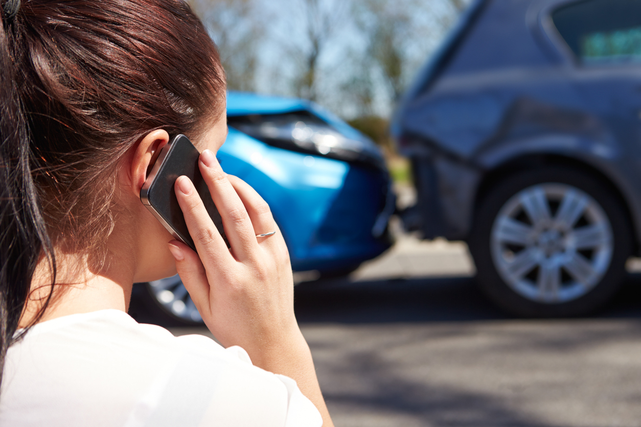 female driver making phone call after traffic accident