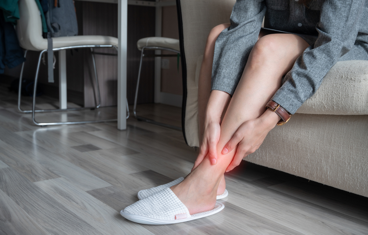 cropped shot of woman hands touching her ankle caused of suffering from ankle pain.