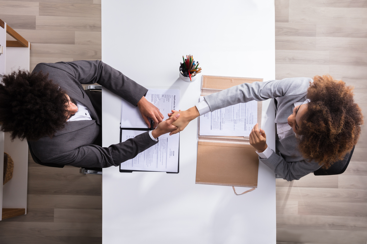 male manager shaking hands with female applicant