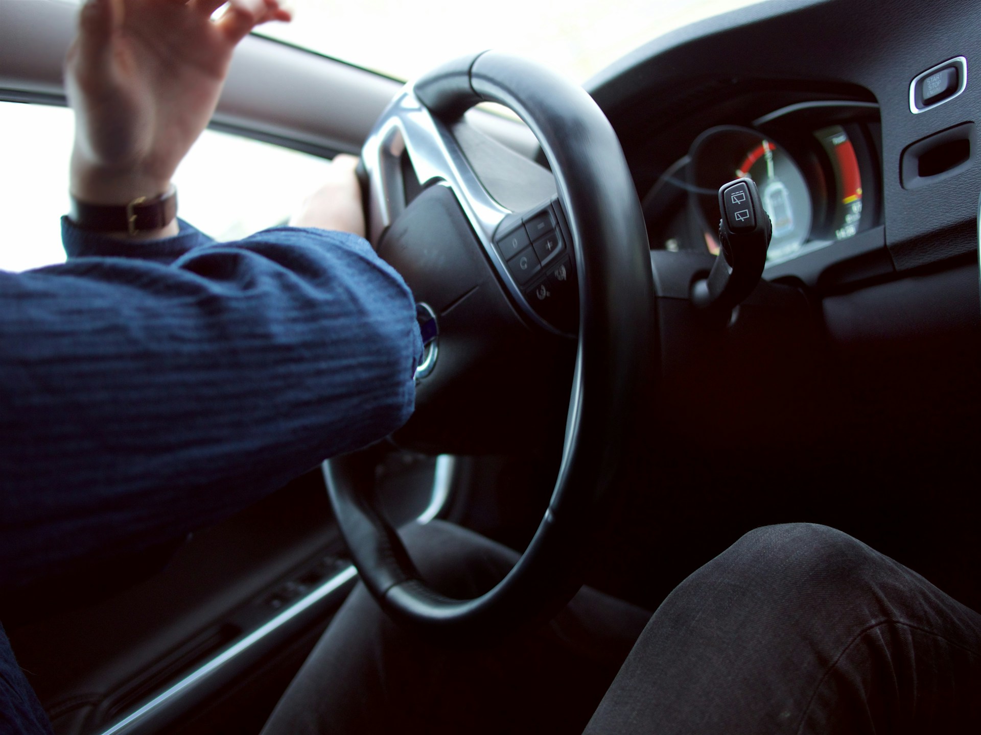 man holding black steering wheel