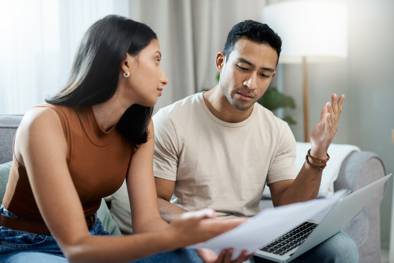 frustrated couple, laptop and financial crisis in debt, mistake or argument on living room sofa at home. man and woman with computer in disagreement for finance, mortgage expenses and bills at house