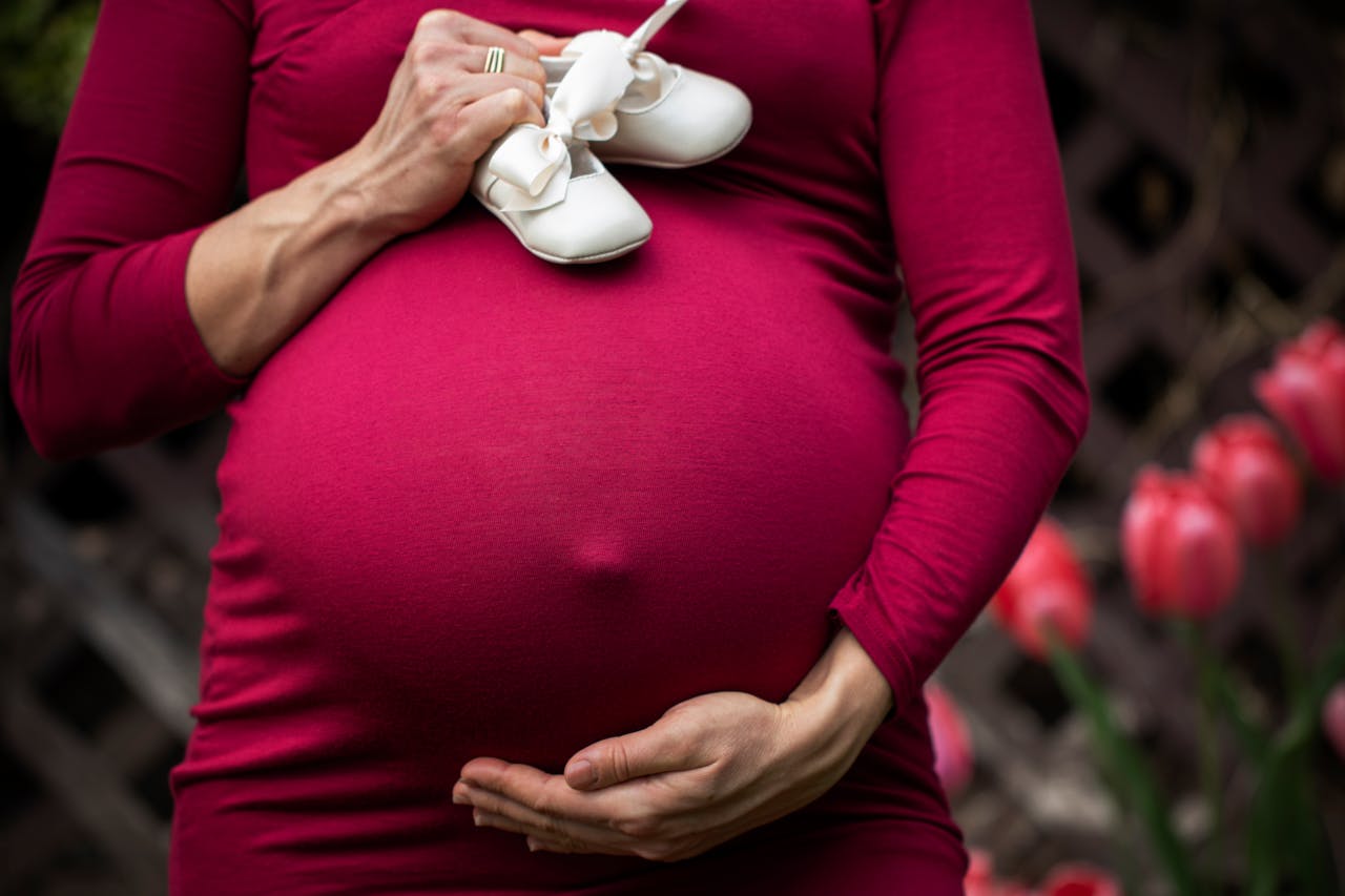 Pregnant Woman Holding baby's shoes